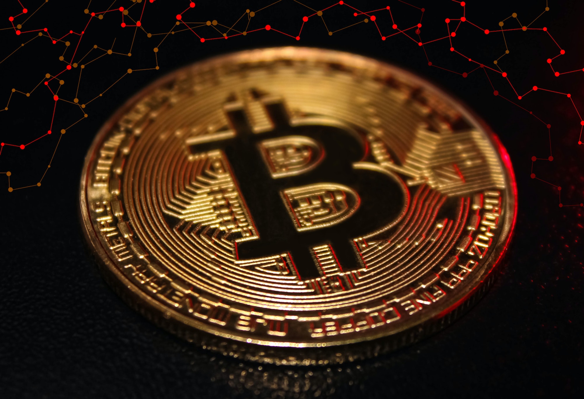 Golden Bitcoin coin over red blockchain network background